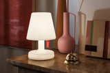Fatboy Edison the Petit leuchtet auf einer Marmorkonsole neben einer Vase